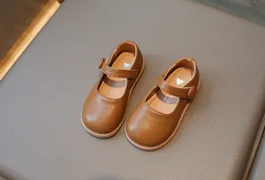 Détail de chaussures Mary Jane brunes pour filles avec bande velcro et logo en cœur