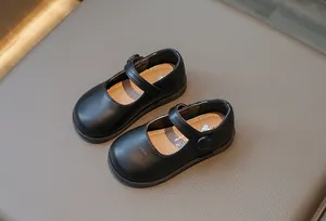 Gros plan de chaussures Mary Jane noires pour filles avec brides auto-agrippantes et semelle souple.
