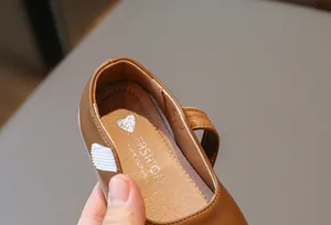 Détail de chaussures Mary Jane marron pour filles avec semelle à motif de cœur.