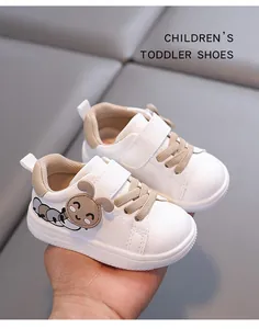 Close-up view of white toddler walking shoes with cute cartoon caterpillar decoration
