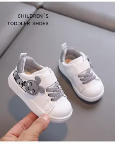 Close-up of white toddler walking shoes with cute grey cartoon character detail