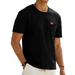 Detail view of men's black oversize t-shirt featuring a chest pocket with orange label