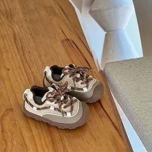Beige and brown breathable mesh toddler sneakers on a natural wooden surface detail view