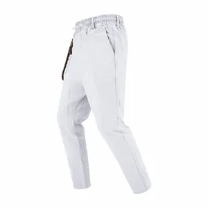 Side view of men's loose white linen casual trousers with elastic waist and drawstring detail.