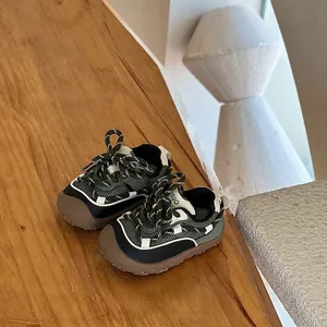 Detailed side view of green mesh toddler walking shoes on a rustic wooden surface