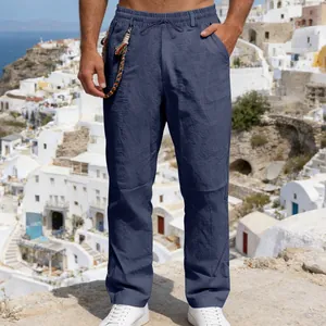 Close-up of men's loose navy blue linen pants with drawstring waist in outdoor scene