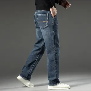 Detail of men's loose straight-leg blue denim jeans for autumn and winter