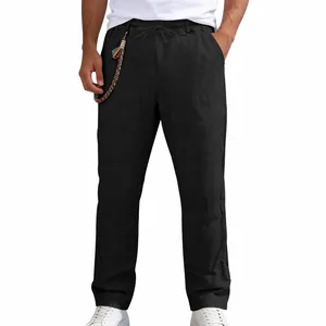 Detail shot of men's loose black linen casual straight-leg trousers with drawstring waist.