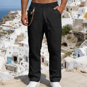 Close-up of men's black loose linen trousers with drawstring waist and braided cord detail
