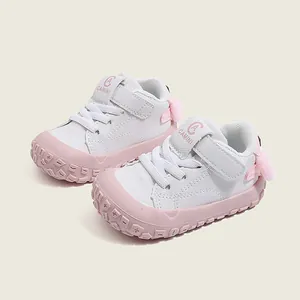 Pink and white toddler walking shoes with soft soles and cute cartoon heel design