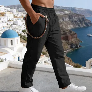 Detailed side view of black loose linen trousers with colorful braided rope accessory.