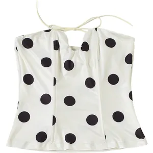Detail of a white polka dot halter neck corset top showing the chic tie design.