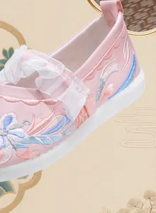 Close-up detail of pink Hanfu embroidered shoes for girls with white ruffle strap