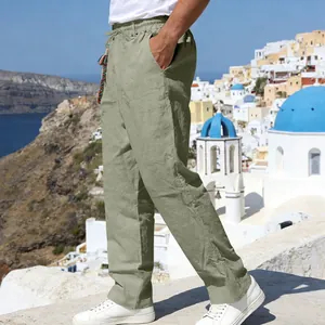 Side view of men's loose sage green linen trousers featuring a drawstring waist in a scenic setting