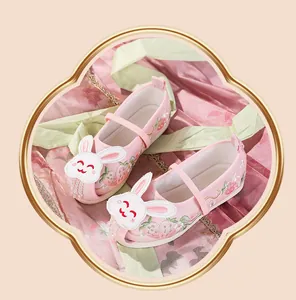 Close-up of pink children's Hanfu embroidered shoes with cute rabbit and strawberry detail