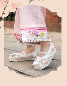 Detail view of white girls' Hanfu shoes featuring cute rabbit and strawberry embroidery.