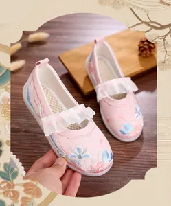 Detail view of pink girls' Hanfu shoes featuring floral embroidery and white lace ruffles