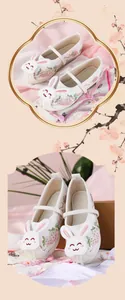 Detailed view of girl's Hanfu shoes with cute rabbit applique and strawberry embroidery
