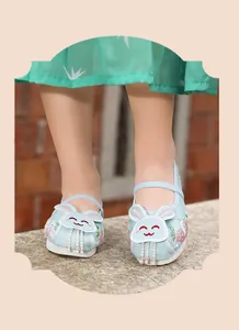 Detailed view of girls' light blue Hanfu embroidered shoes with cute rabbit and tassels