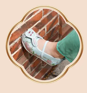 Detailed view of children's light blue Hanfu shoe with strawberry and rabbit embroidery
