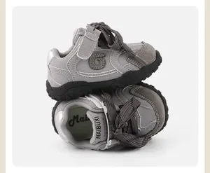 Detailed macro view of grey toddler sneakers featuring soft soles and adjustable velcro straps
