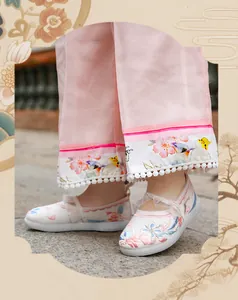 Close-up of girl's white Hanfu shoes with colorful butterfly and flower embroidery
