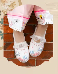 Close-up of white girls' embroidered Hanfu shoes with floral patterns and lace ruffles