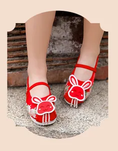 Close-up of red Hanfu embroidered shoes for girls with cute rabbit and pearl tassels