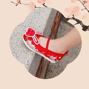 Close-up of red traditional Hanfu embroidered shoes for girls with cute rabbit ear decor