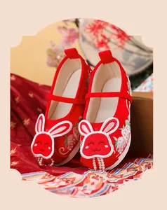 Close-up of red Hanfu embroidered shoes for girls with cute rabbit and bead detail