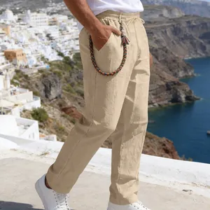 Detail view of men's loose linen straight-leg pants with braided decorative chain