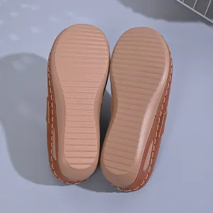 Detailed view of non-slip wedge soles with size 37 stamp on brown clogs