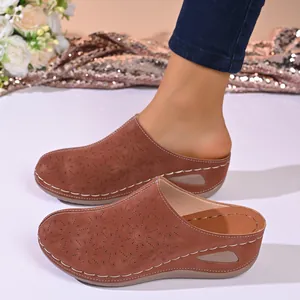 Detailed side view of brown leather platform clogs with floral laser-cut patterns