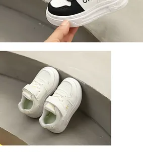 Hochwertige Detailaufnahme weißer Kinder-Plateau-Sneaker auf grauen Betonstufen