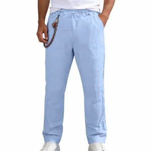 Front view of men's light blue loose linen trousers with drawstring and tassel