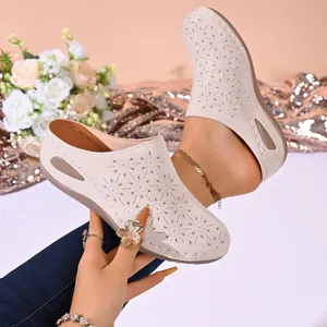 Detailed view of beige women's platform mules with a delicate hollow-out floral design