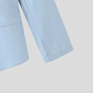 Dettaglio del polsino della manica e della patta della tasca di un blazer azzurro chiaro