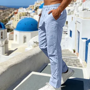 Close-up side view of men's light blue linen trousers in a scenic Mediterranean resort