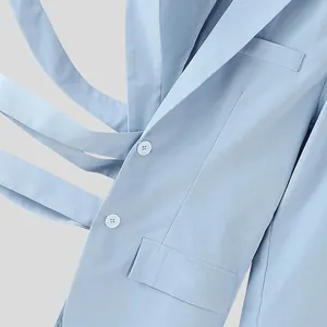 Vista dettagliata del blazer da uomo azzurro con esclusivo design a cinghie incrociate e bottoni