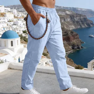 Detailed view of light blue men's loose linen casual straight-leg pants in scenic outdoor setting