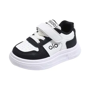 Klassische schwarz-weiße Halbschuhe für Kinder mit dicker Sohle und Klettverschluss