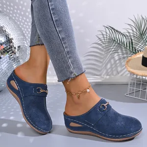 Close-up of navy blue wedge platform clogs worn by a model in a lifestyle setting