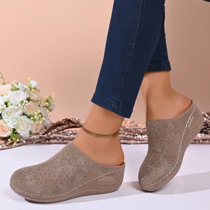 Detail view of women's taupe closed-toe platform mules with floral laser-cut patterns