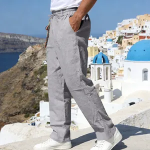 Side view of grey loose-fit linen casual trousers for men in a holiday setting