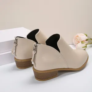 Vue arrière de bottines beiges à petit talon montrant le zip et la texture grainée