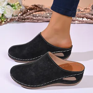Women's black laser-cut floral clogs with comfortable wedge heel and thick sole detail.