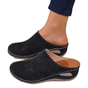 Women's black closed-toe platform mules with floral laser-cut patterns and thick soles.