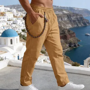 Detail view of men's loose khaki linen trousers with colorful woven rope accessory