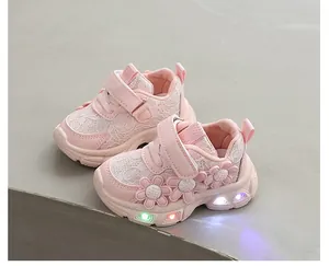 Détail de baskets roses pour filles avec appliques fleurs et semelles lumineuses à LED colorées.