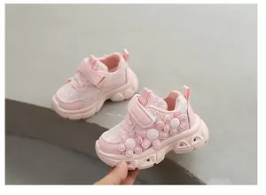 Détail de baskets roses pour tout-petit avec appliques florales et semelles LED